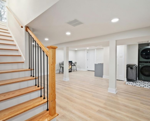 wood stairs going down to a finished basement - Barefoot Construction basement remodel
