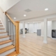 wood stairs going down to a finished basement - Barefoot Construction basement remodel